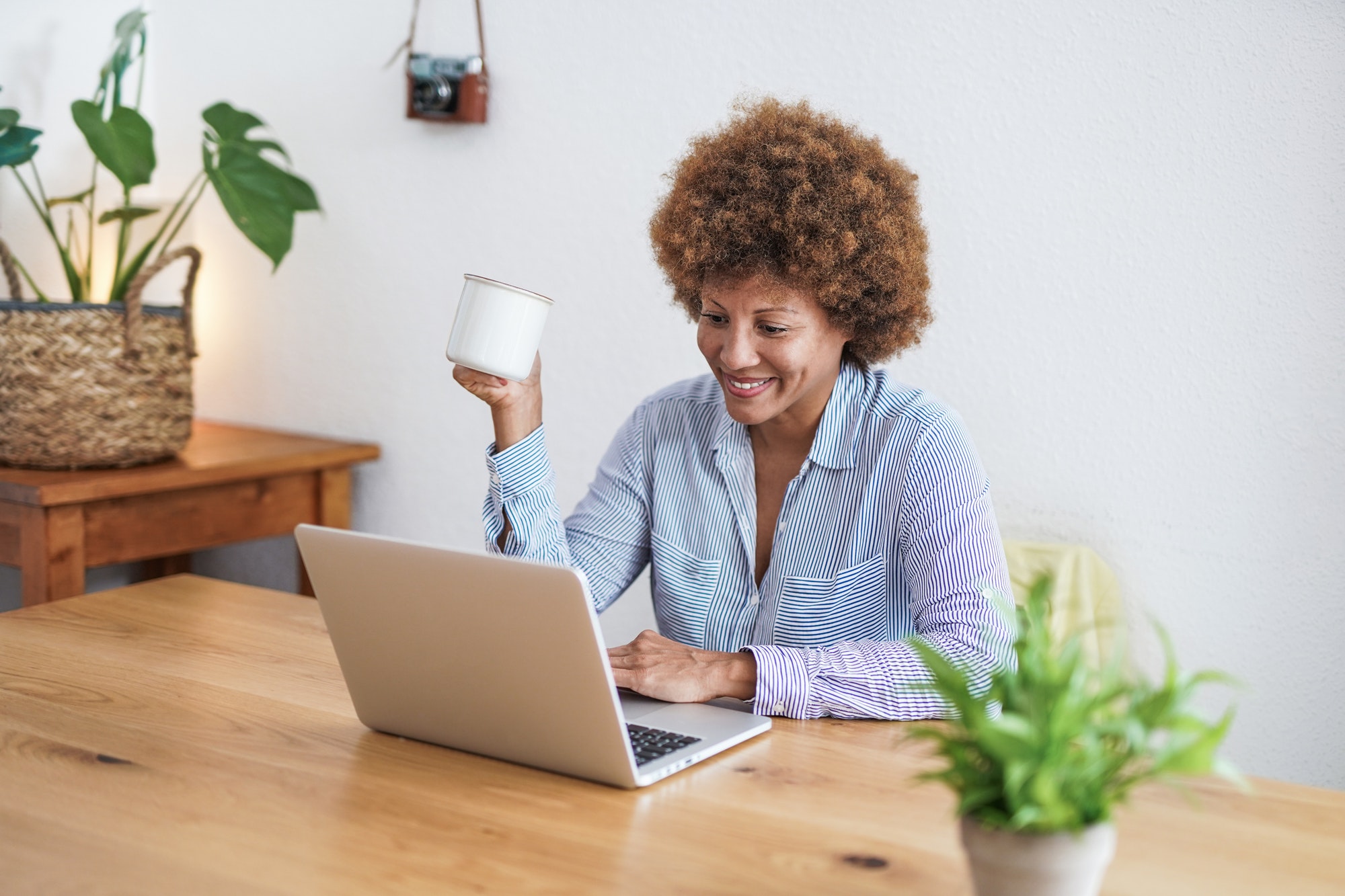 Mature african woman working from home with computer laptop